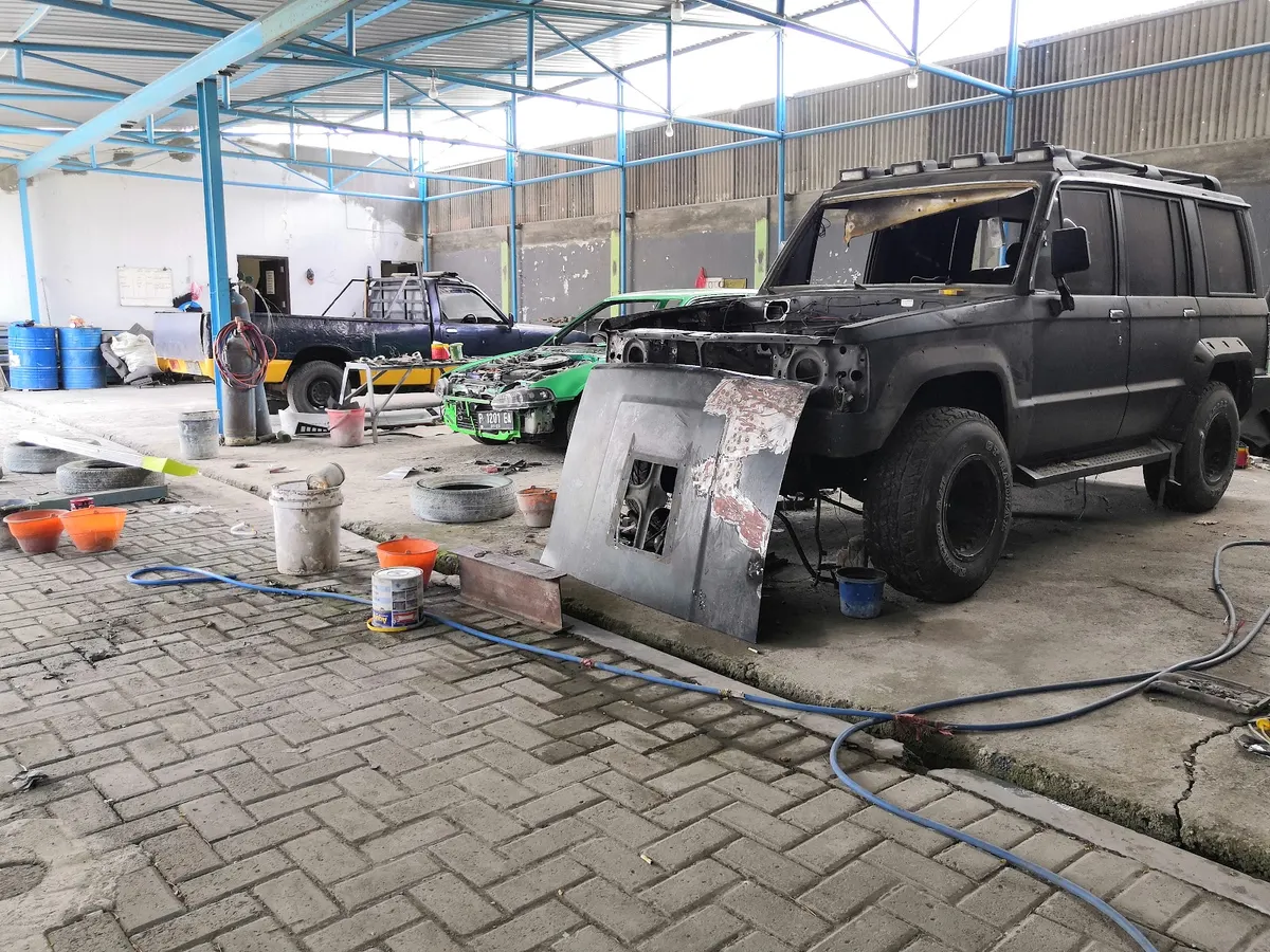 Area bengkel AUTO PRIMAJAYA dengan mobil sedang dikerjakan
